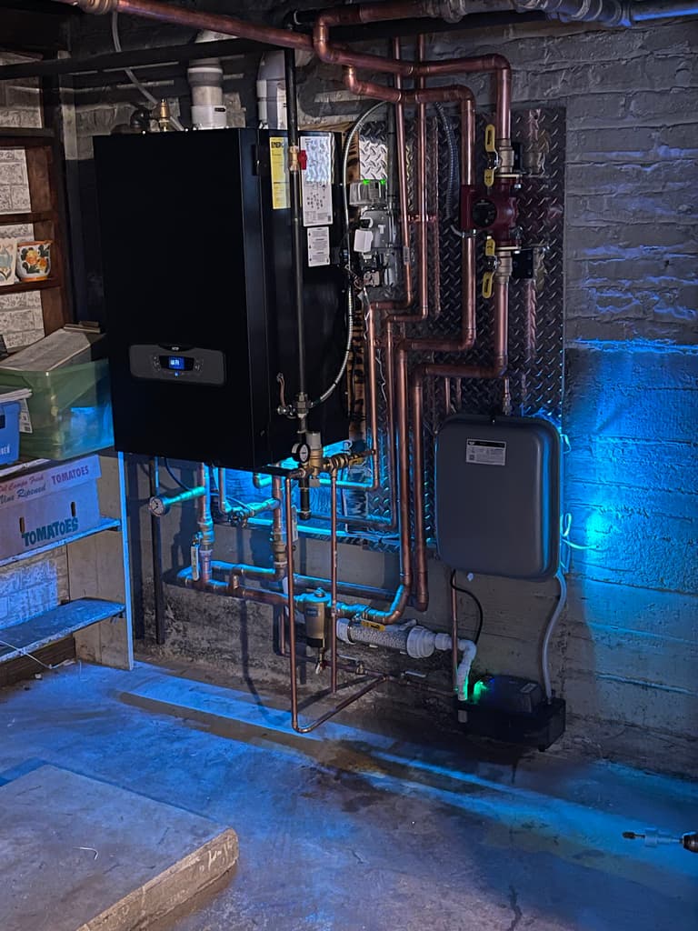 Five Sons hydronic heating installation with copper piping and brand-blue lighting